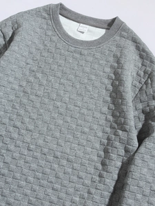 Detail of grey waffle knit long sleeve shirt showing neckline texture and fabric label