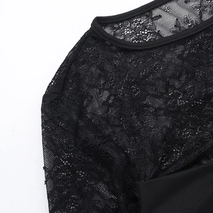 Détail de la broderie en dentelle noire et de la finition de l'encolure ronde sur le haut