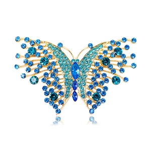 Vintage gold butterfly brooch with blue crystal rhinestones on a white background