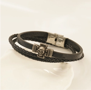 Details eines mehrlagigen Lederarmbands mit Totenkopf und Metallverschluss in Silber