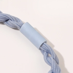 Macro detail of high-elasticity braided hair tie in light blue with textured knit pattern
