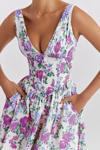 Detail shot of a floral summer dress featuring a deep V-neckline and functional side pockets