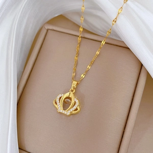 Elegant gold crown necklace with micro-pave crystals on a soft silk background