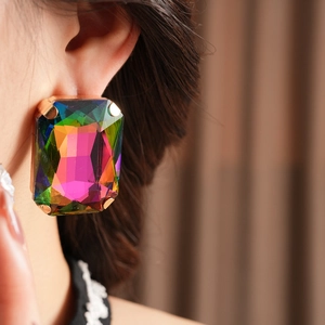 Macro shot of vintage oversized rectangular earrings with vibrant rhinestones on model