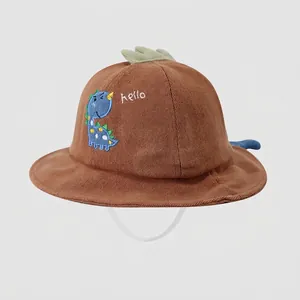 Detail of baby cotton bucket hat featuring blue dinosaur embroidery and 3D decorative fins