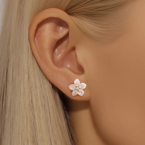 Close-up of a S925 silver floral stud earring with shell texture and cz center on ear
