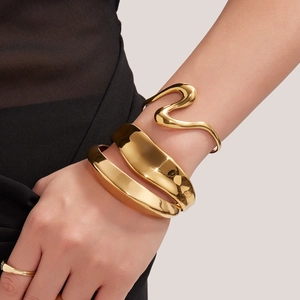 Brazaletes abiertos geométricos anchos y con curvas en S de acero inoxidable bañado en oro 18k
