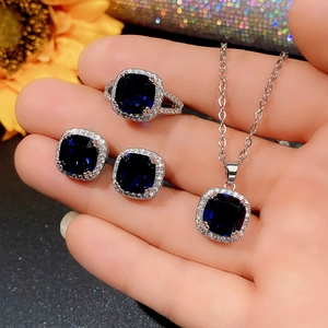 Elegant silver jewelry set featuring square blue gemstones in a classic halo design