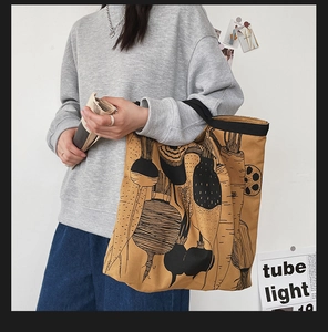 Detail shot of khaki canvas tote bag featuring black minimalist vegetable line art