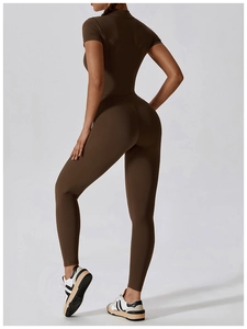 Macro shot of dark brown short sleeve yoga bodysuit featuring slim-fit stretch fabric texture