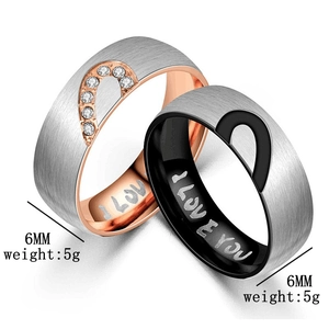 Detail of couple rings showing matching heart patterns and I LOVE YOU engraving