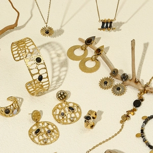 Golden bohemian jewelry set featuring sunflower charms with black and white stone inlays