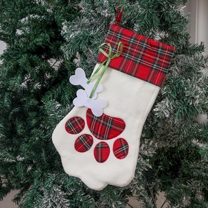 Chaussette de Noël en patte de chien avec plaid rouge et polaire sur un sapin de Noël