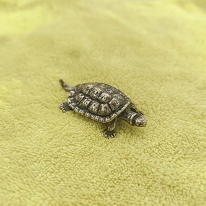Handcrafted vintage brass turtle figurine placed on a soft textured background surface