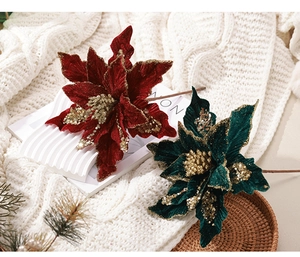 Détail des fleurs de poinsettia en velours avec paillettes dorées en rouge et vert festif