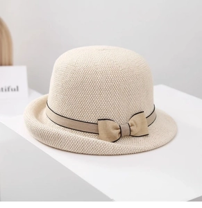 Dettaglio di un cappello da sole in paglia beige con fiocco kaki e tesa curva