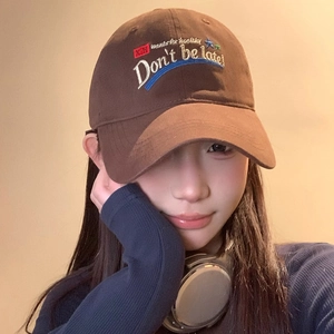 Brown vintage baseball cap with letter embroidery worn by a female model for a casual look