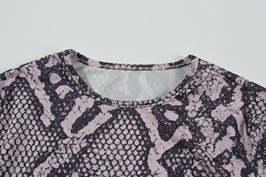 Close-up of the crew neck stitching and pink snakeskin print on long-sleeve top