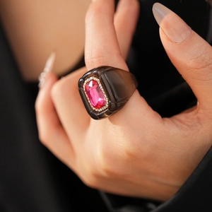 Détail macro d'une bague vintage en résine avec pierre rose et pavé étincelant