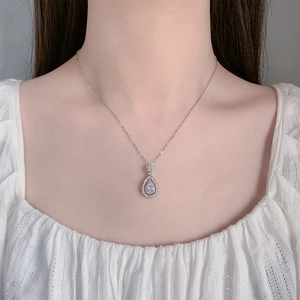 Close-up of a pear-shaped zircon pendant necklace worn on a woman's neck
