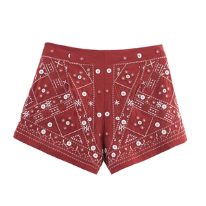 Detail von roten High-Waist-Shorts mit weißer geometrischer Stickerei und Knopfverzierung