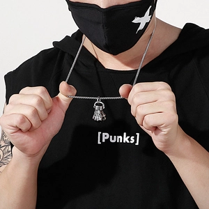 Hip hop silver fist pendant necklace worn by a model in a black hoodie and mask