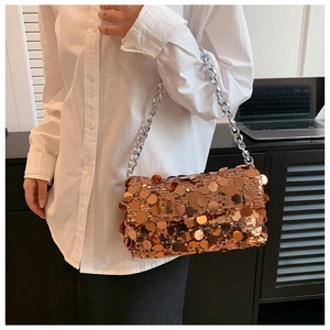 Close-up of sparkling gold sequins and silver chain strap on a trendy crossbody bag