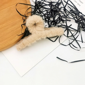 Elegant beige plush hair claw clip with a soft faux fur knot design for winter styling