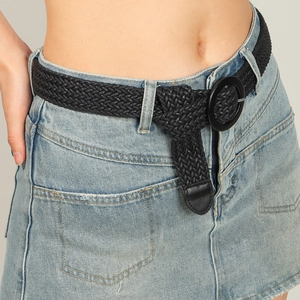 Close-up of black woven belt with round buckle on denim skirt with a bohemian style