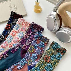 Detail shot of vintage floral embroidered mid-calf socks with colorful 3D knitted patterns