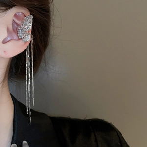 Detail shot of a silver butterfly ear cuff with sparkling zircon and long metal tassels