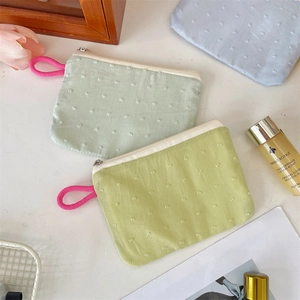Detailed texture of knitted makeup pouches with 3D dots and metal zipper closures