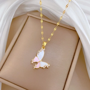 Close-up of a gold wave chain necklace featuring a pink enamel butterfly pendant with crystals