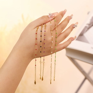 Detailed view of colorful beaded cross bracelets with adjustable gold chains on hand