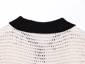 Detailed close-up of knit polo collar and crochet texture on black and white top