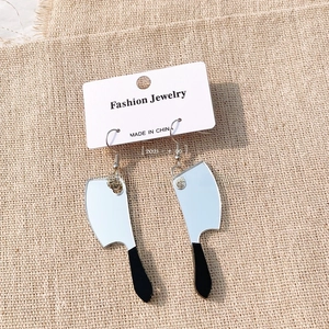 Detail view of creative silver mirror kitchen knife earrings on jewelry display card