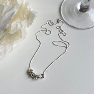 Macro view of S925 sterling silver snake chain necklace with five minimalist ring charms