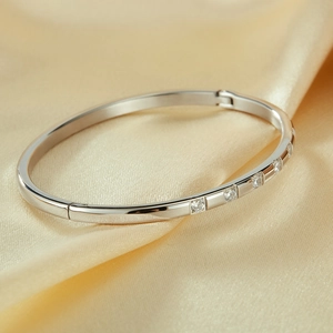 Close-up of polished silver stainless steel bangle with inlaid round cubic zirconia stones