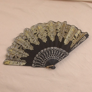 Detailed view of black lace folding fan with gold embroidery and carved plastic ribs