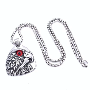 Gros plan du pendentif tête d'aigle avec œil rouge sur une chaîne en acier vintage