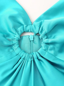 Détail du dos de la robe en satin bleu sarcelle avec découpe ronde et fermeture éclair