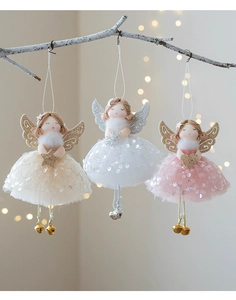 Three Christmas angel ornaments with gauze skirts and bell feet on a warm light background