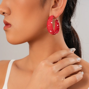 New Chinese style red polka dot fabric hoop earrings worn by a model in a profile view