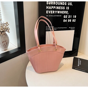 Detailed view of pink pleated handbag with slim handles on an artistic aesthetic background
