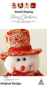 Close-up of knit snowman doll detail with red and gold hat and carrot nose