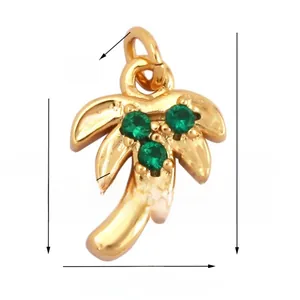 Detail view of a gold-plated palm tree charm with green zircons and dimension markings