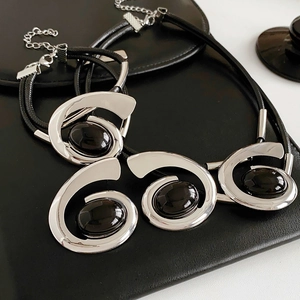 Detail of silver double-layer necklace and bracelet set with oval black gemstones