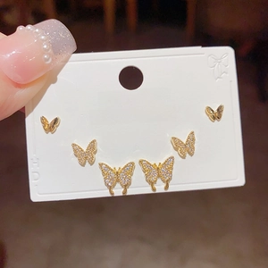 Detailed close-up of a 3-pair butterfly stud earring set with zircons and gold finish