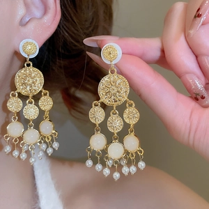 Détail de boucles d'oreilles vintage françaises avec pierre en résine et perles