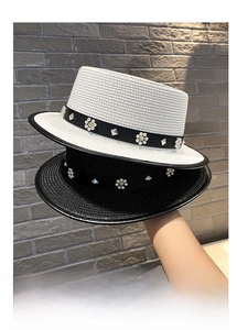 Close-up of elegant straw hats with pearl flower bands and metallic buckle details